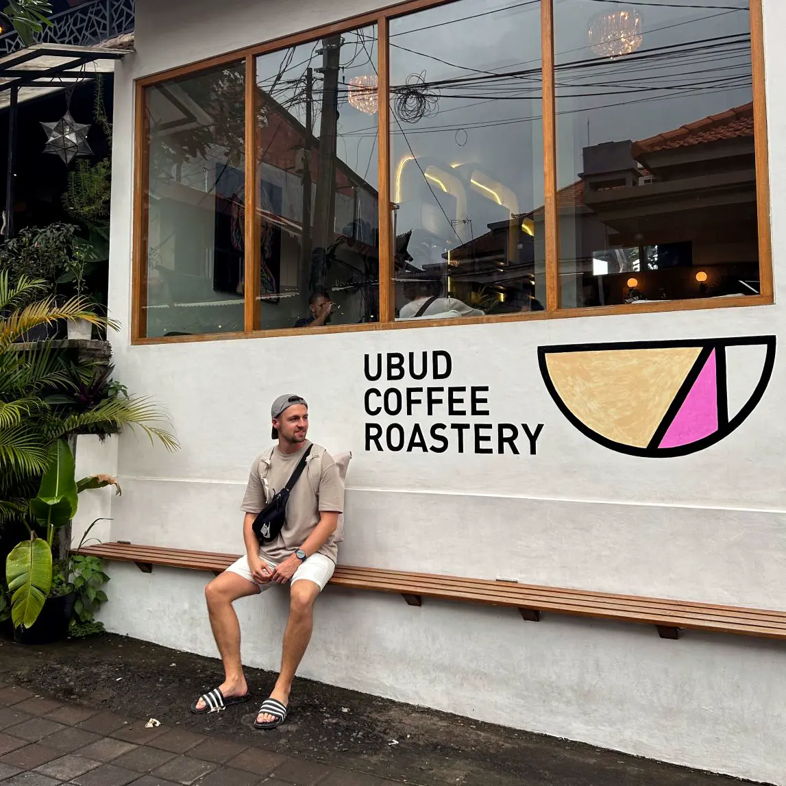 Christian Rauscher sitzt auf einer Bank vor dem Kaffee Ubud Coffee Roastery.
