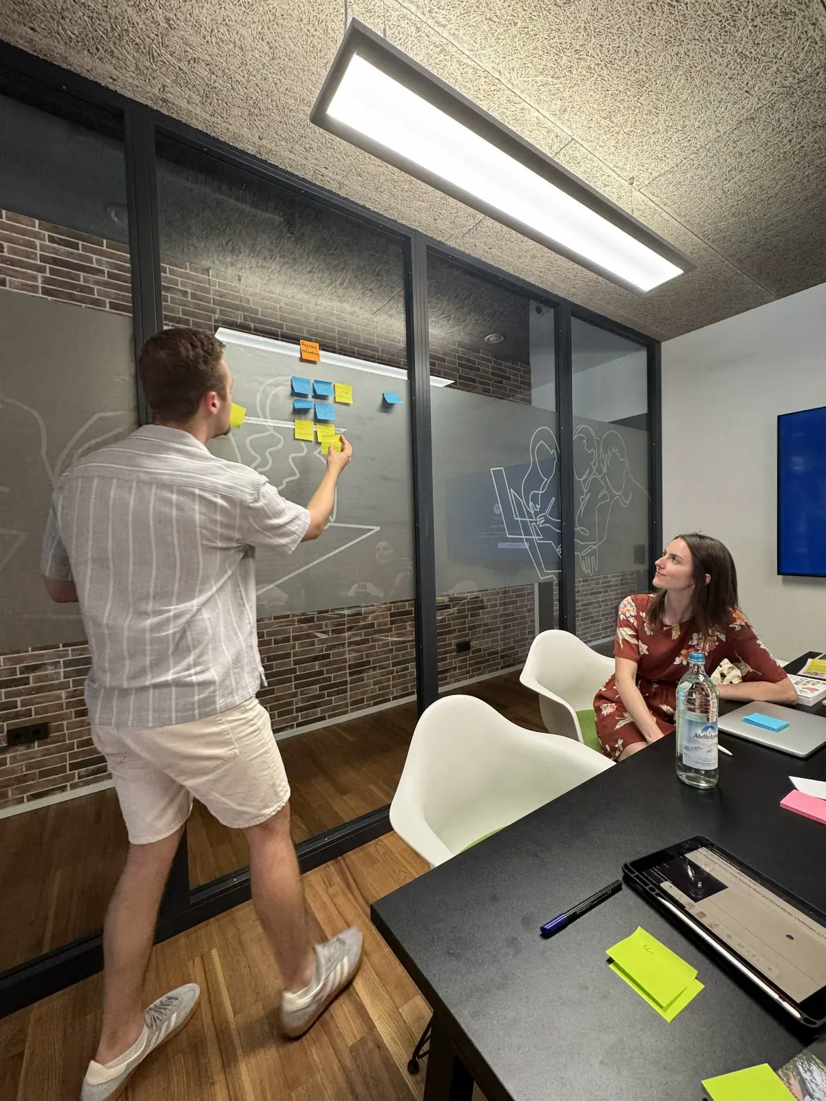 Das Foto zeigt Christian Rauscher beim Kleben eines Zettels während eines Brainstormings.