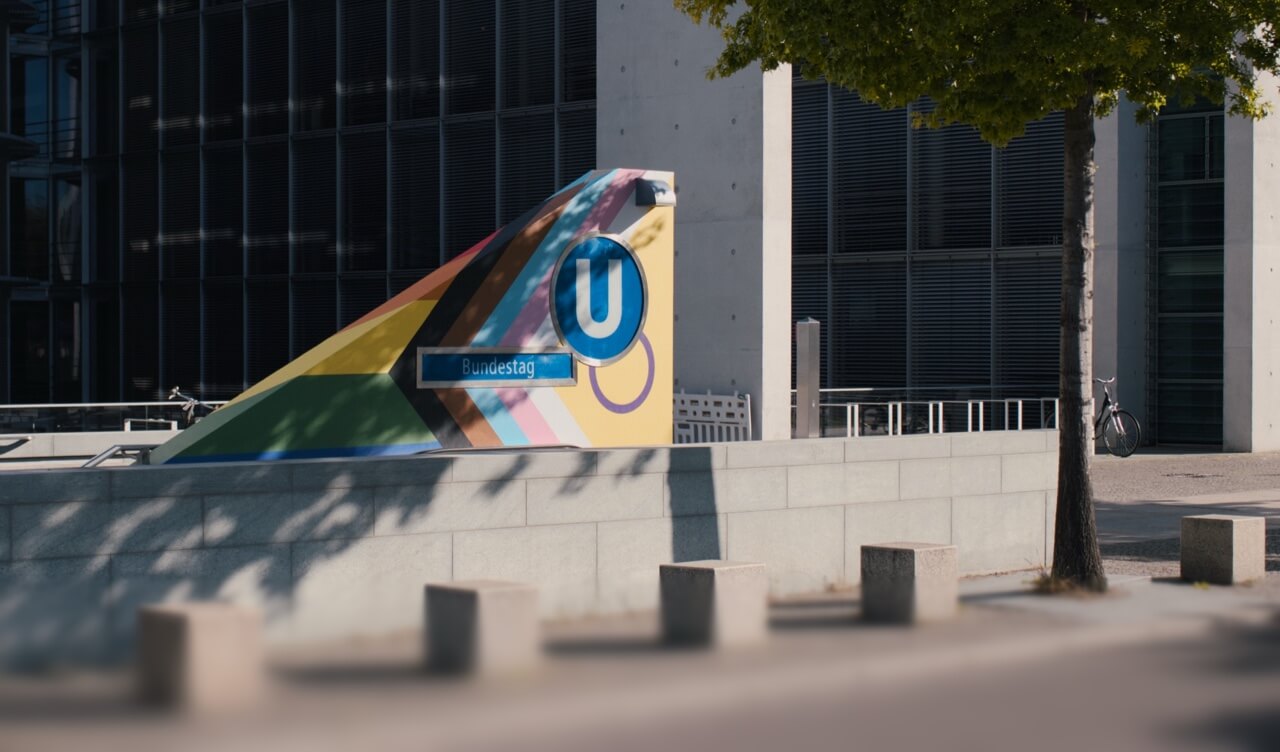 Der farbenfrohe Eingang zur U-Bahn-Station Bundestag vor einem modernen Bürogebäude.