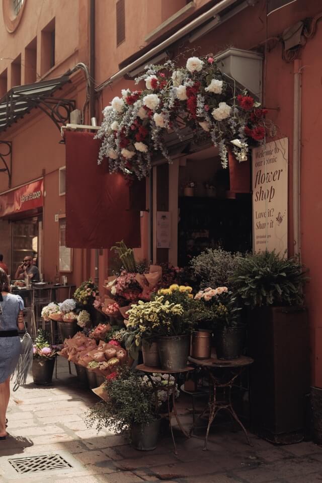Der Eingang zu einem Blumenladen ist mit zahlreichen bunten Blumen und Pflanzen dekoriert.