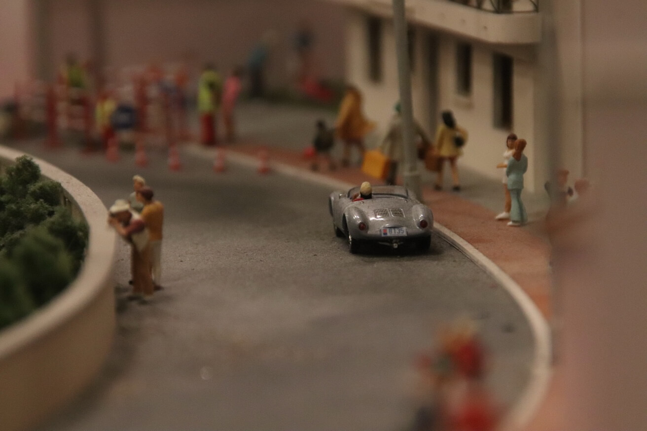 Ein silbernes Oldtimer-Modellauto fährt in einer Kurve in der Miniaturlandschaft des Miniatur Wunderlandes.