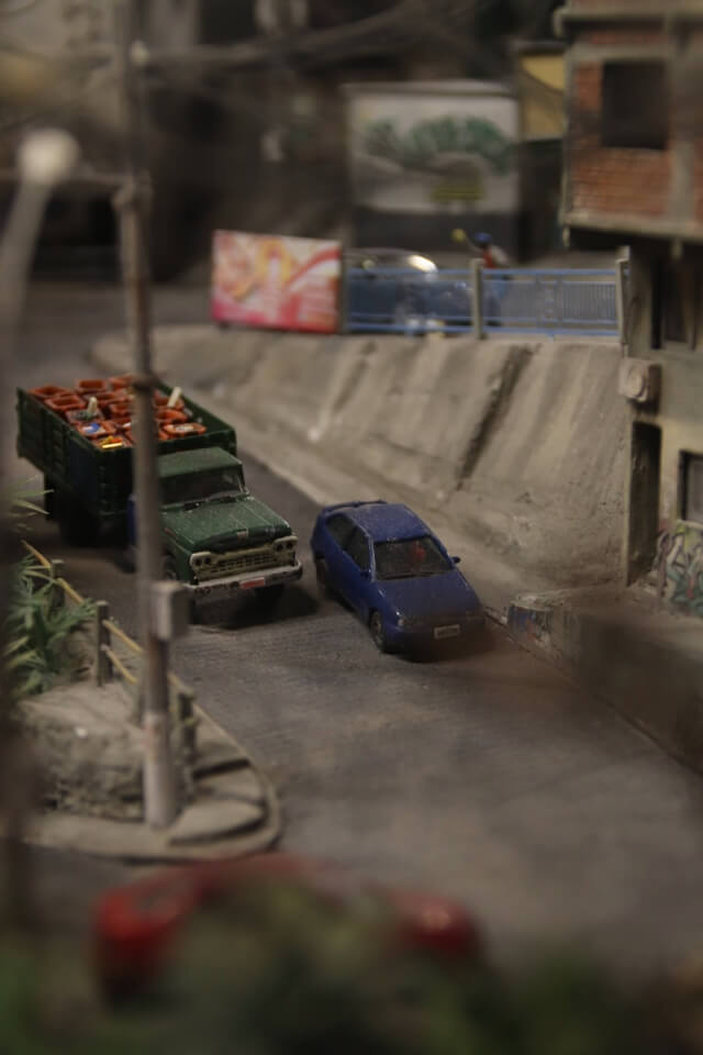 Eine detailreiche Modellbauszene mit einem blauen Auto und einem grünen LKW im Miniatur Wunderland.