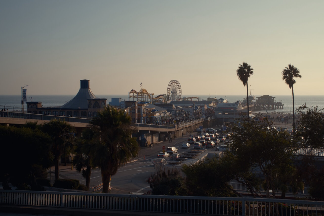 Eine Ansicht des belebten Santa Monica Piers mit dem Riesenrad, gesehen von einer erhöhten Position bei Tag.