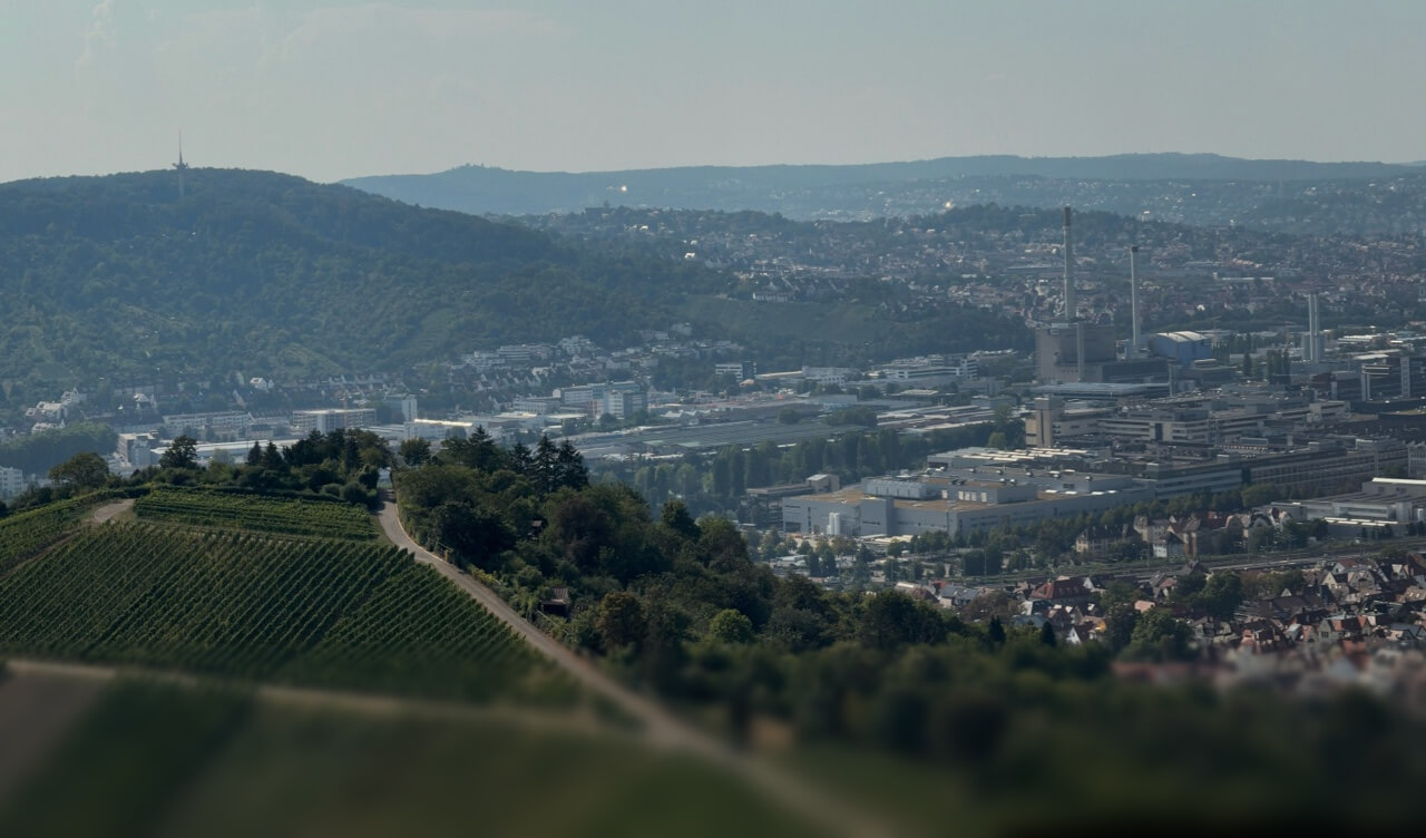 Ein weiter Blick von einem Weinberg über das Stuttgarter Stadtgebiet mit Industrieanlagen und dem Fernsehturm.