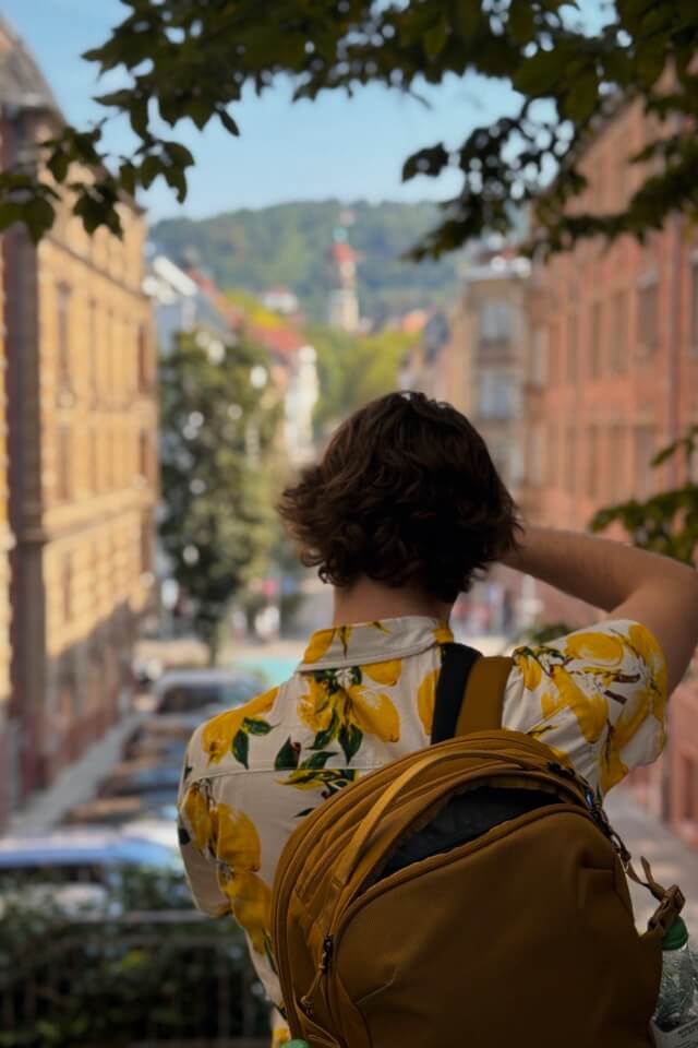 Eine Person im Hemd mit Zitronenmuster blickt von hinten auf eine Straße in Stuttgart.