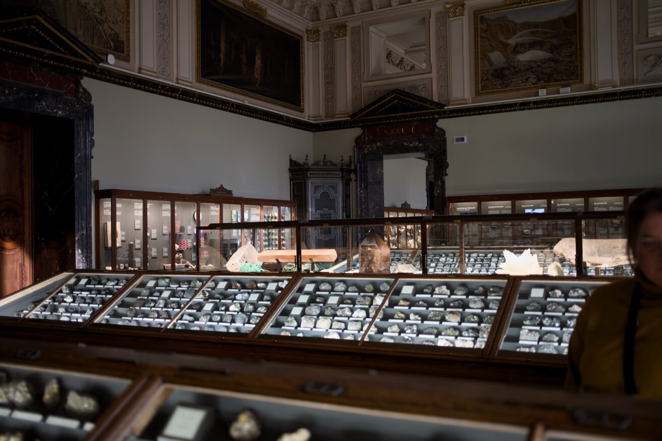 Ein Ausstellungsraum im Naturhistorischen Museum mit vielen Glasvitrinen, die eine Mineraliensammlung zeigen.