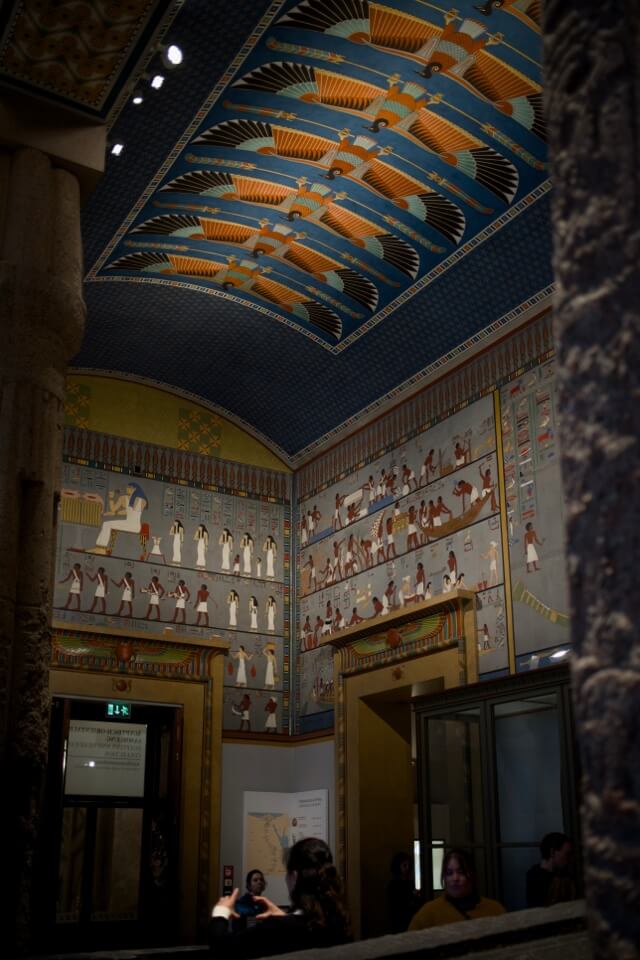Ein Museumsraum mit Wänden und Decken, die vollständig mit altägyptischen Malereien verziert sind.