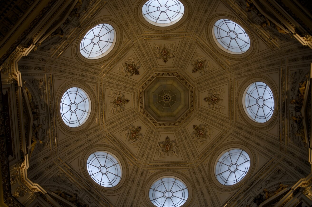 Die reich verzierte, achteckige Kuppeldecke des Kunsthistorischen Museums mit ihren runden Fenstern.