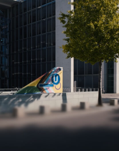 Der farbenfrohe U-Bahn-Eingang Bundestag steht vor einem modernen Bürogebäude in Berlin.