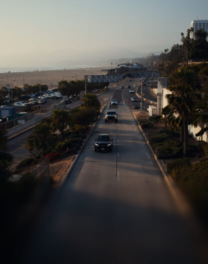 Blick auf den Pacific Coast Highway, der bei Dunst am weiten Sandstrand von Santa Monica entlangführt.